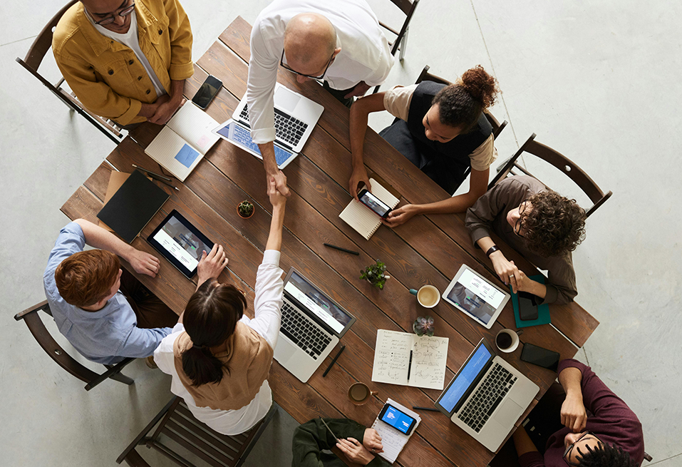 Recruitment specialists discussing candidate placements around a desk in an office